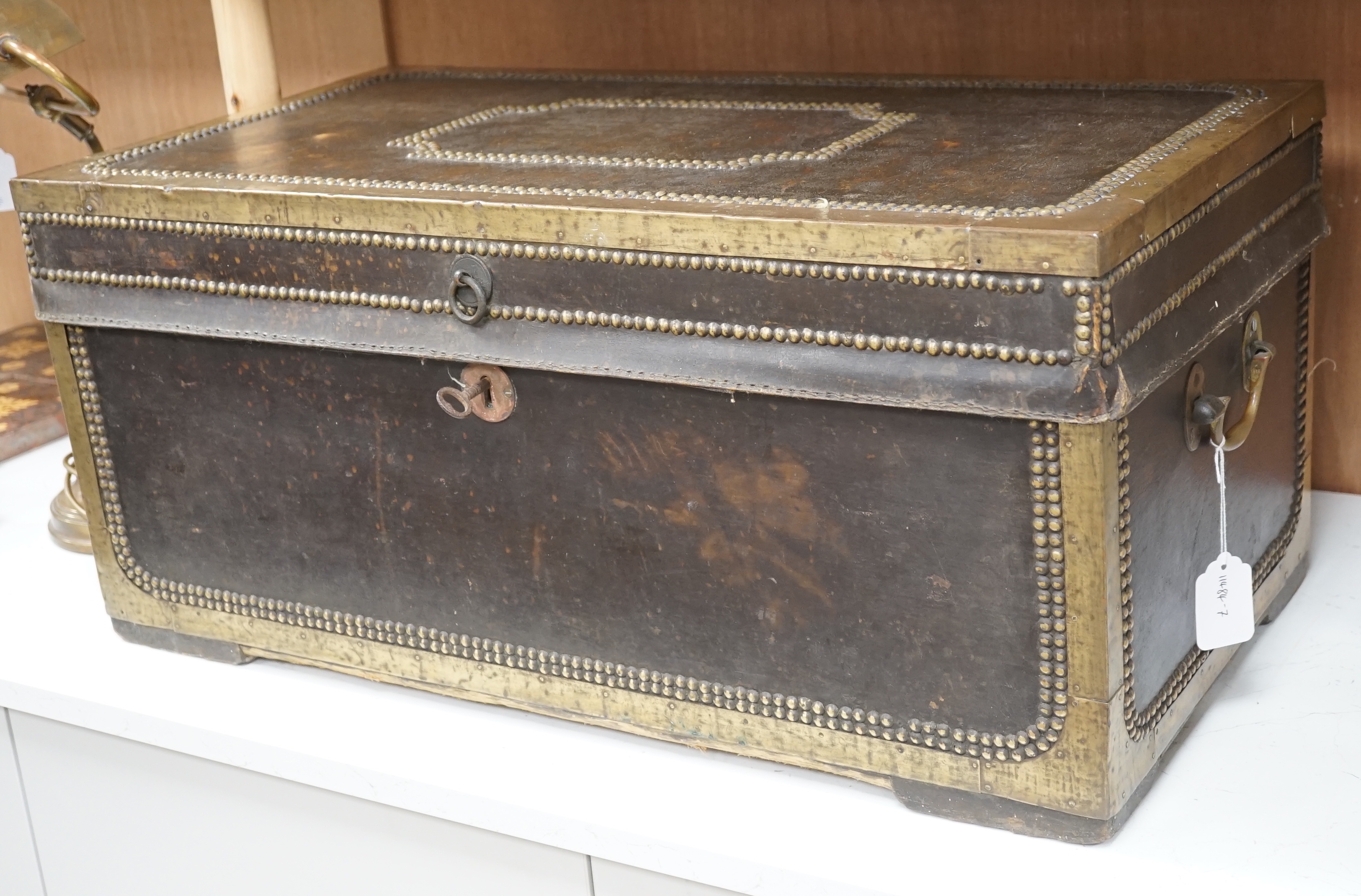 A 19th century leather and brass studded and mounted travelling trunk with metal and printed paper lining, 73.5 cm wide x 33cm high x 39cm deep